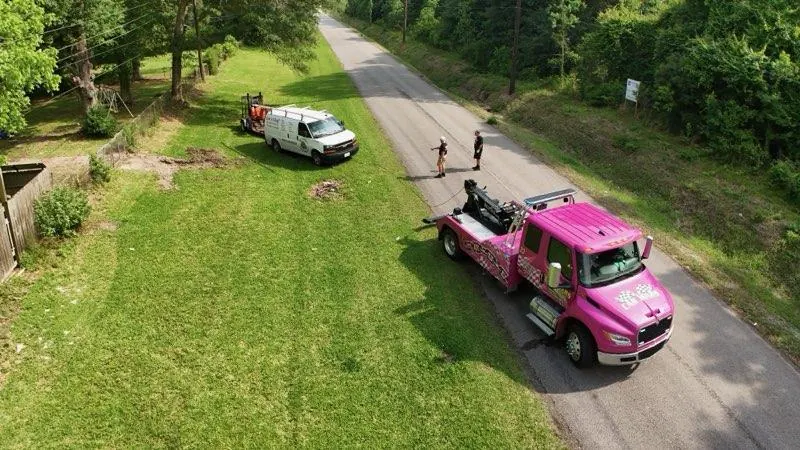Aerial view of pink Car Wars wrecker performing roadside recovery in Orange, TX